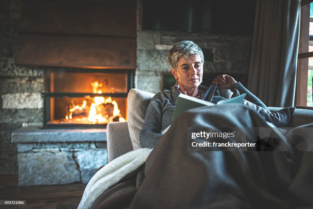 Mulher lendo um livro no sofá
