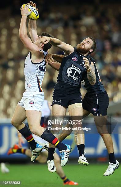 Patrick Dangerfield of the Crows marks the ball against Zach Tuohy and Chris Yarran of the Blues during the round 10 AFL match between the Carlton...