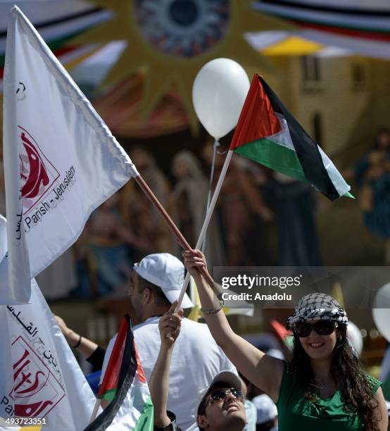 People wave Palesinian national flags as Pope Francis arrives at the Manger Square, next to the Church of the Nativity in the West Bank town of...