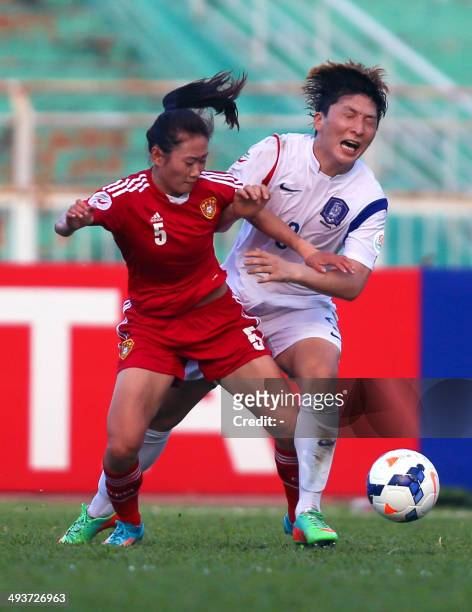 Chinese defender Wu Haiyan fights for the ball with South Korean forward Park Eun Sun during their Women's Asia 2014 Football Championship final...