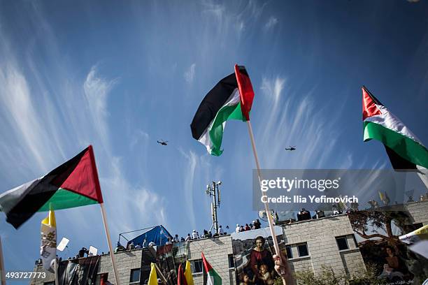 Pope Francis flies over the square in a helicopter on his way to Manger Square to take part in a Mass held at the Church of Nativity as crowds watch...