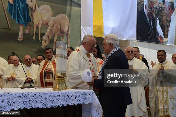 Pope Francis shakes hands with Palestinian President Mahmoud Abbas ahead of an open-air mass at the Manger Square, outside the Church of the Nativity...