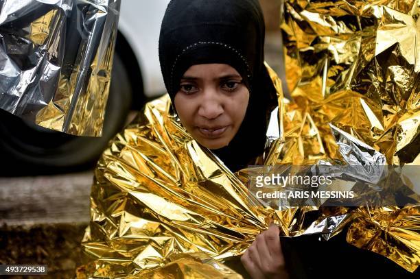 Woman cries as she wraps an emergency blanket around herself child as she arrives with other refugees and migrants on the Greek Island of Lesbos on...