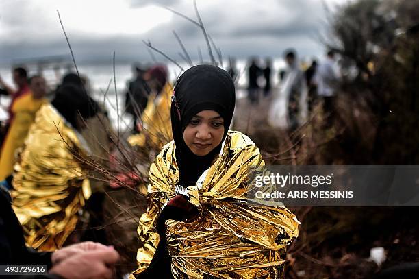 Child cries as she wraps an emergency blanket around herself as she arrives with other refugees and migrants on the Greek Island of Lesbos on October...