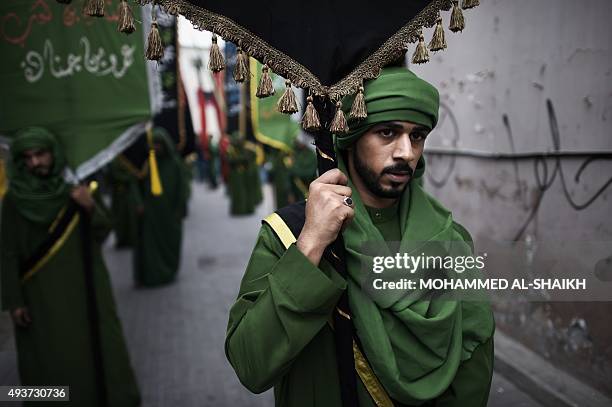 Bahraini Shiite Muslim men take part in a ceremony commemorating Ashura, which marks the seventh century slaying of Imam Hussein, the grandson of...