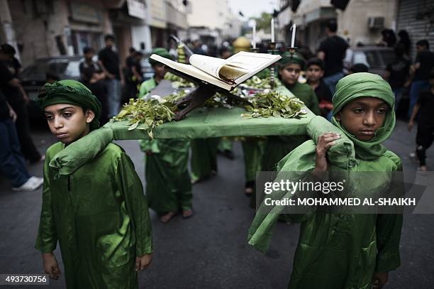 Bahraini Shiite Muslims take part in a ceremony commemorating Ashura, which marks the seventh century slaying of Imam Hussein, the grandson of...