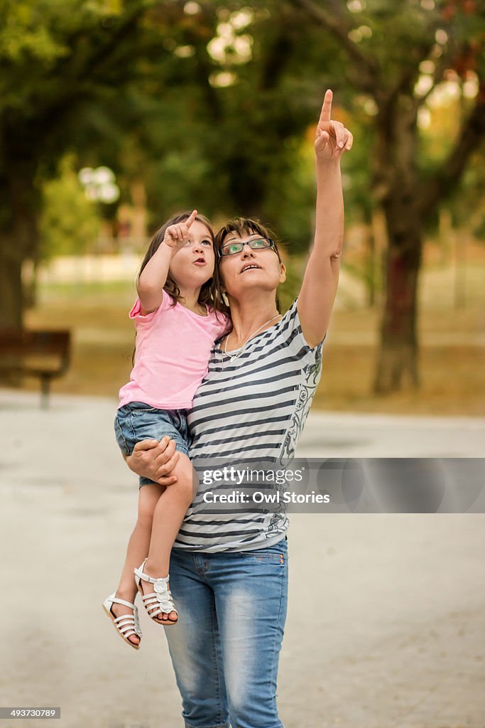 Grandmother holding granddaughter in a park