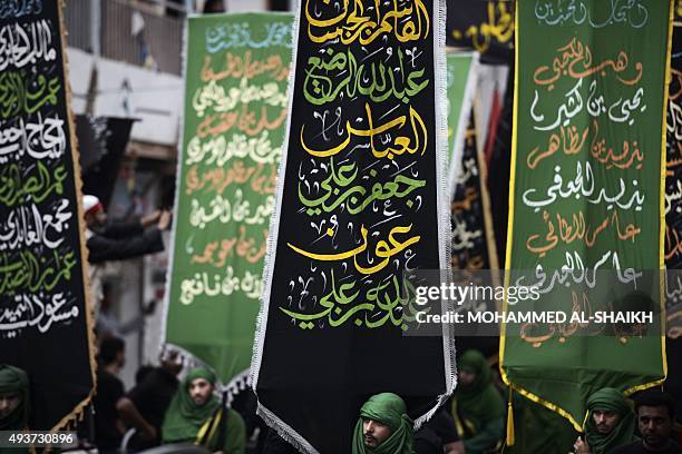 Bahraini Shiite Muslims take part in a ceremony commemorating Ashura, which marks the seventh century slaying of Imam Hussein, the grandson of...