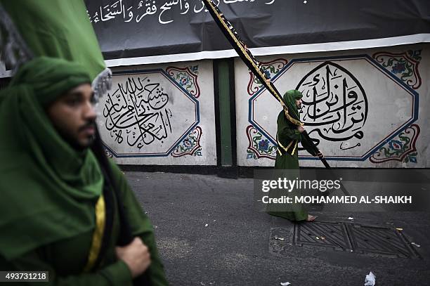 Bahraini Shiite Muslims take part in a ceremony commemorating Ashura, which marks the seventh century slaying of Imam Hussein, the grandson of...