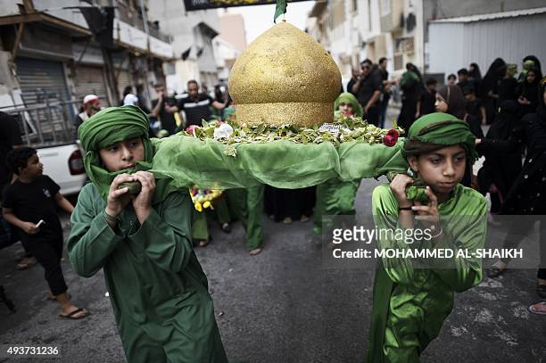 Bahraini Shiite Muslims take part in a ceremony commemorating Ashura, which marks the seventh century slaying of Imam Hussein, the grandson of...