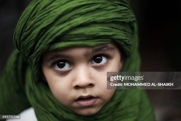 Bahraini Shiite Muslim child takes part in a ceremony commemorating Ashura, which marks the seventh century slaying of Imam Hussein, the grandson of...