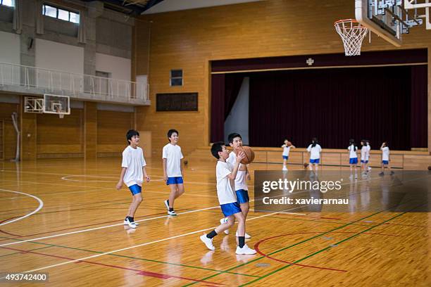 japonés niños de práctica de básquetbol del gimnasio escolar - physical education fotografías e imágenes de stock