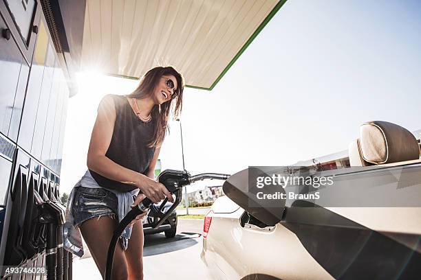 low angle view of happy woman at gas station. - refueling 個照片及圖片檔