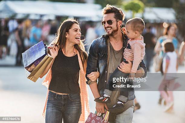 young happy parents having fun with their son in shopping. - shop stockfoto's en -beelden