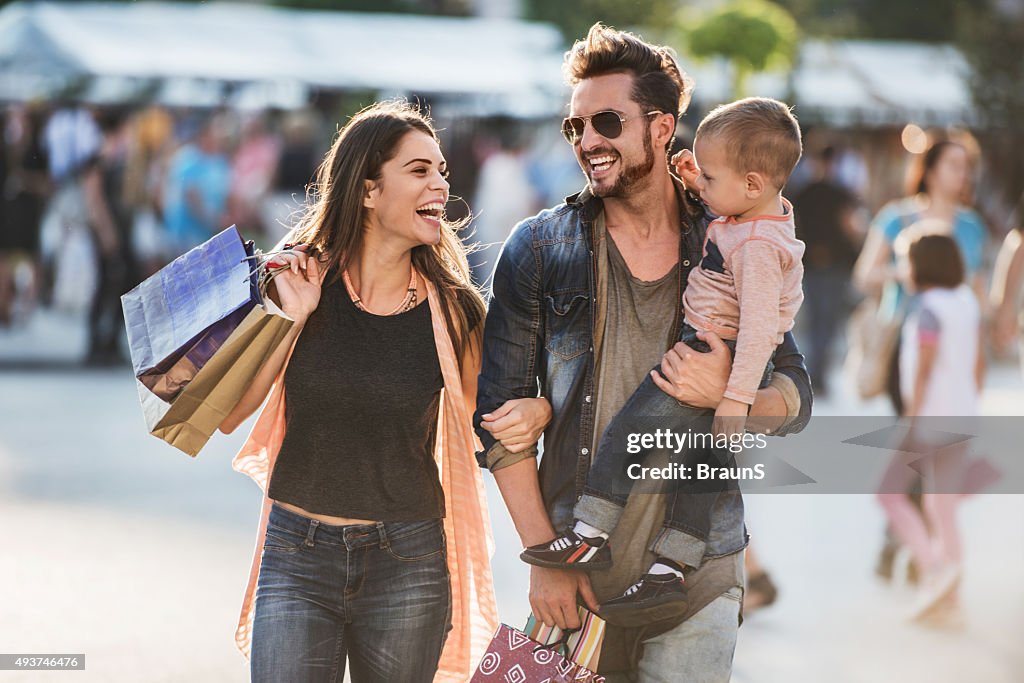 Young happy parents having fun with their son in shopping.