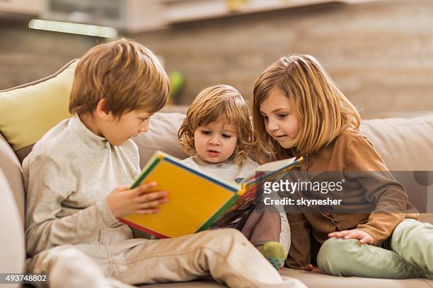 children reading picture book at home. - storytelling children stock pictures, royalty-free photos & images