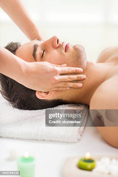 young man getting facial massage at spa. - man massage stock pictures, royalty-free photos & images