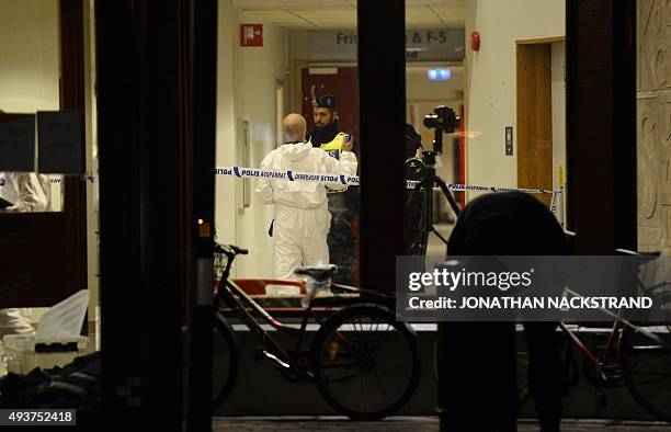Forensic officers investigate at the primary and middle school Kronan in Trollhattan, southwestern Sweden, on October 22 where a masked man armed...