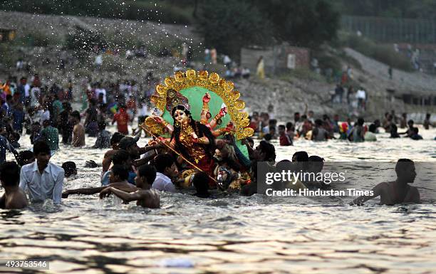 Devotees immersing idol of Goddess Durga in river Yamuna at Okhla Barrage on the occasion of Dashmi on October 22, 2015 in New Delhi, India. Puja...