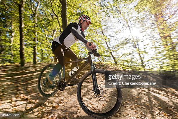 senior man mountain biking at møns klint denmark - mountainbiken stockfoto's en -beelden