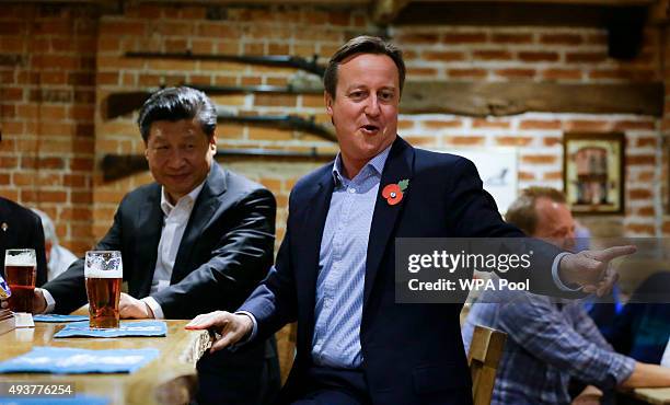 China's President Xi Jinping and Britain's Prime Minister David Cameron drink a pint of beer during a visit to the The Plough pub on October 22, 2015...