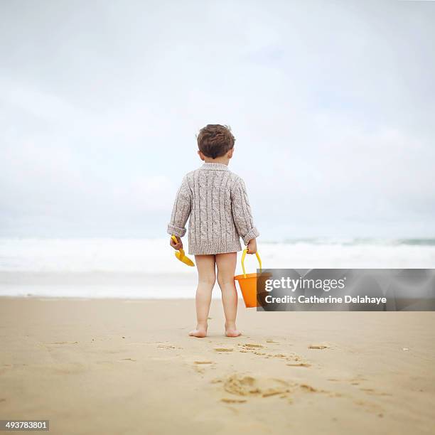 a 3 years old boy playing on the beach - sand pail and shovel stock pictures, royalty-free photos & images