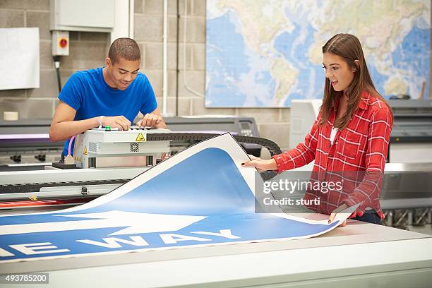 young woman working at a digital printers - drukkerij stockfoto's en -beelden