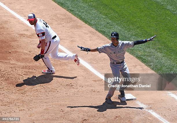 Derek Jeter of the New York Yankees signals that he is safe at first base after beating a throw to Adam Dunn in the 2nd inning against the Chicago...