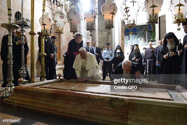 In this handout provided by the Israeli Government Press Office , Pope Francis worships at the Stone of Anointing at the Church of the Holy Sepulchre...