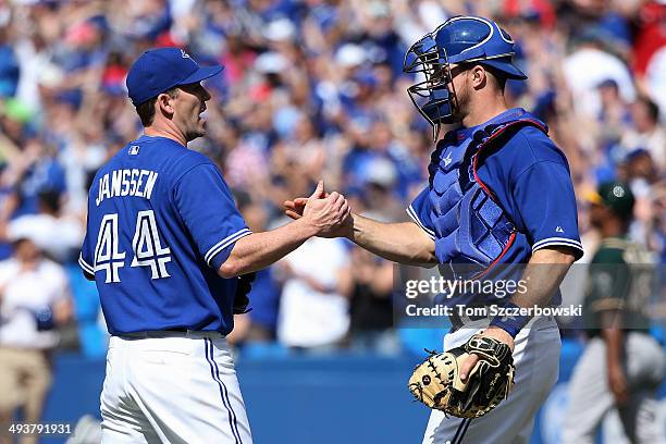 Casey Janssen of the Toronto Blue Jays celebrates their victory with Erik Kratz during MLB game action against the Oakland Athletics on May 25, 2014...