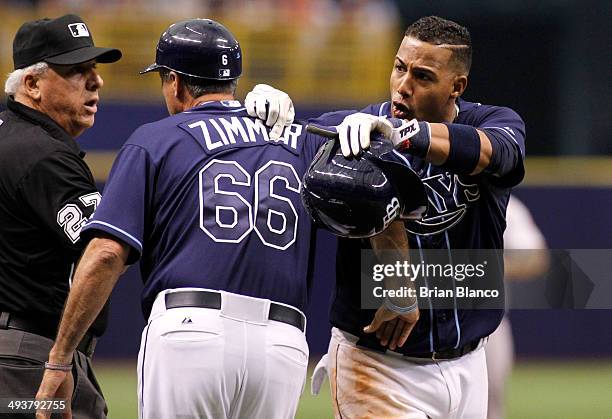 Umpire Larry Vanover and third base coach Tom Foley of the Tampa Bay Rays attempts to hold back Yunel Escobar of the Tampa Bay Rays as he argues with...