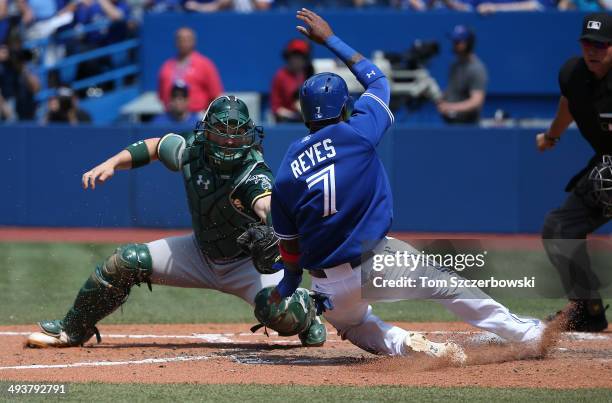 Jose Reyes of the Toronto Blue Jays is tagged out at home plate in the fifth inning during MLB game action by Derek Norris of the Oakland Athletics...