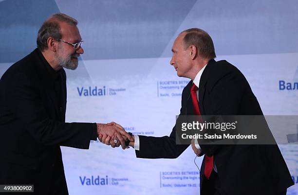 Russian President Vladimir Putin greets Iran's Parliament Speaker Ali Larijani during the Valdai International Discussion Club meeting on October 22,...