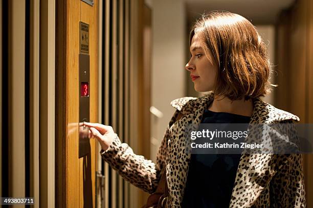 young woman calling elevator - lift button stock pictures, royalty-free photos & images