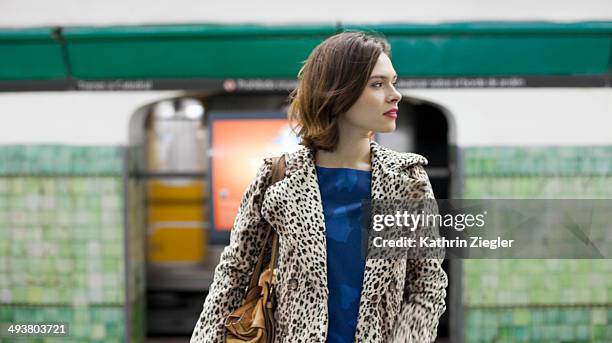 young woman waiting at subway station - luipaardprint stockfoto's en -beelden