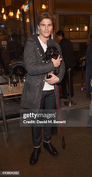 Oliver Cheshire and Huxley The Dog attend Whistles Men 1st birthday celebrations at Protein Galleries on October 22, 2015 in London, England.