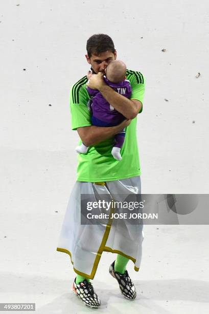 Real Madrid's goalkeeper Iker Casillas holds his son as Real Madrid's players celebrate their Champions League title at the Santiago Bernabeu stadium...