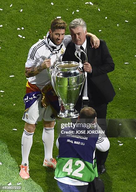 Real Madrid's defender Sergio Ramos and Real Madrid's Italian coach Carlo Ancelotti pose with the trophy as Real Madrid's players celebrate their...