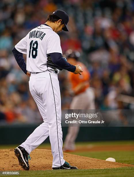 Starting pitcher Hisashi Iwakuma of the Seattle Mariners pauses on the mound after giving up a two-run homer to Marc Krauss of the Houston Astros in...