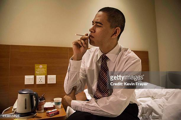 Chinese actor and United States President Barack Obama impersonator Xiao Jiguo, 29 years, smokes before working on a film set with Kim Jung Un...