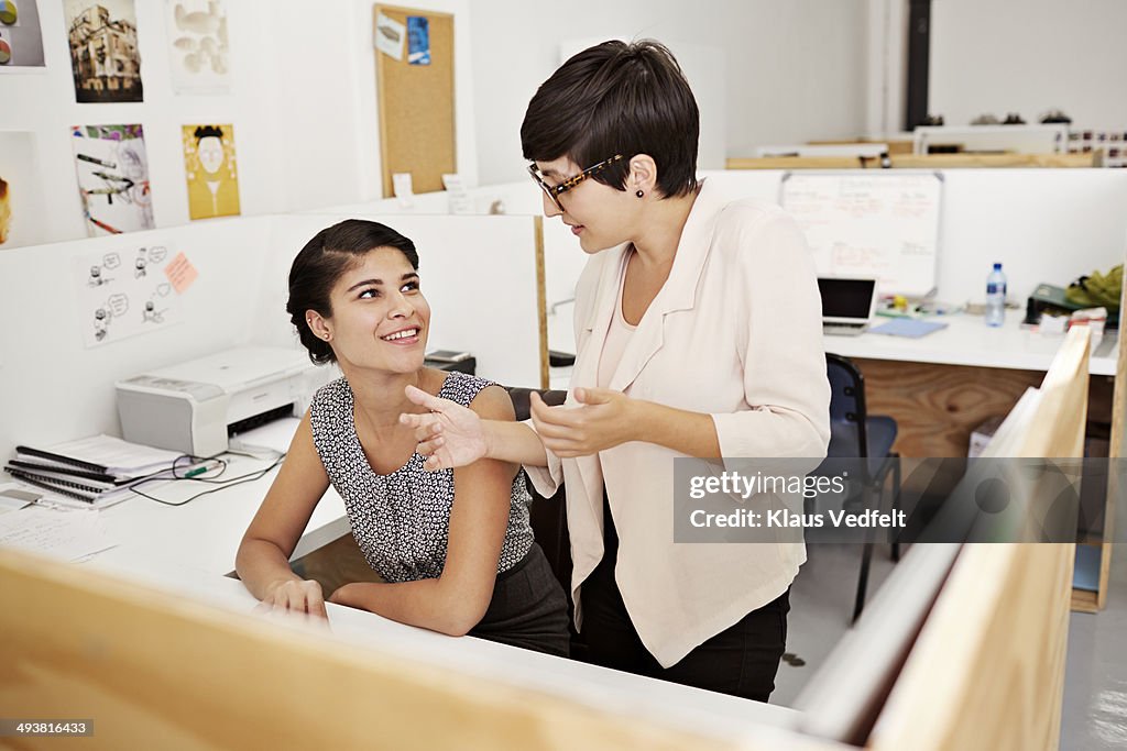 Creative coworkers having a talk by desk