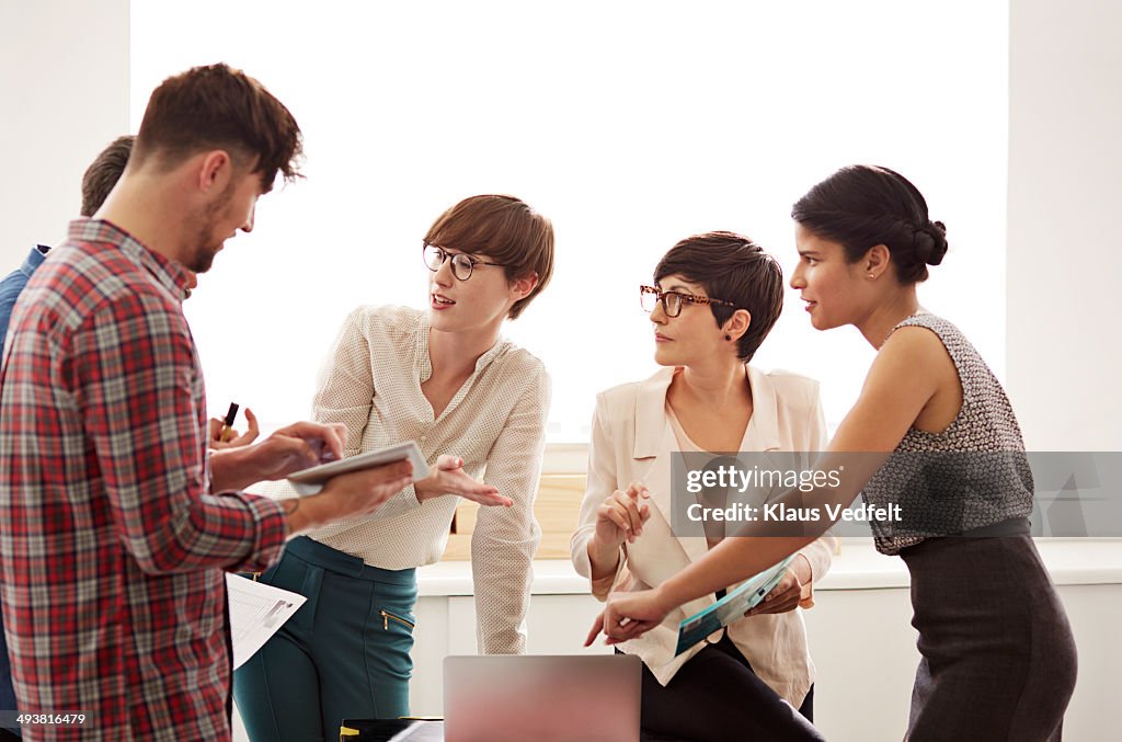 Creative coworkers having stand up meeting