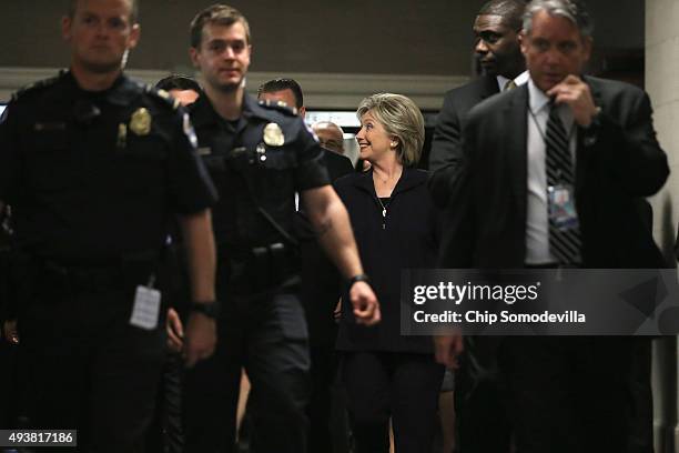 Surrounded by a number of security guards and police officers, Democratic presidential candidate and former Secretary of State Hillary Clinton leaves...