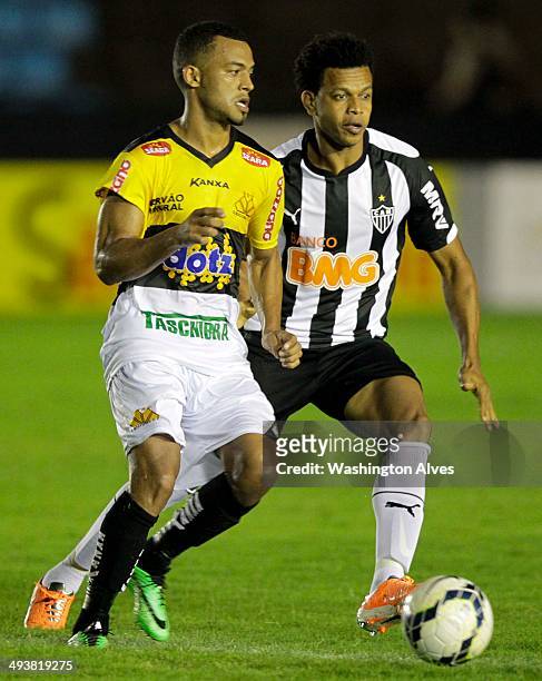 Emerson Conceicao of Atletico MG struggles for the ball with Joilson of Criciuma during a match between Atletico MG and Criciuma as part of...