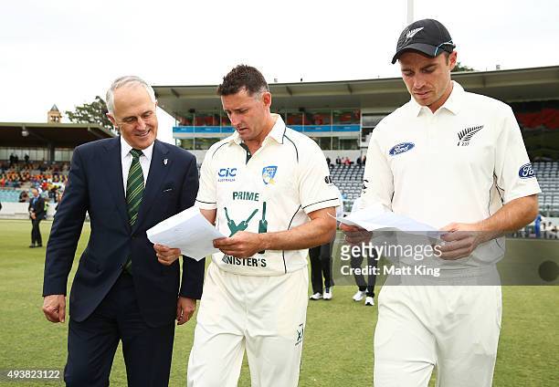 The Prime Minister of Australia Malcolm Turnbull checks the final team sheets with the Prime Minister's XI captain Michael Hussey and New Zealand...
