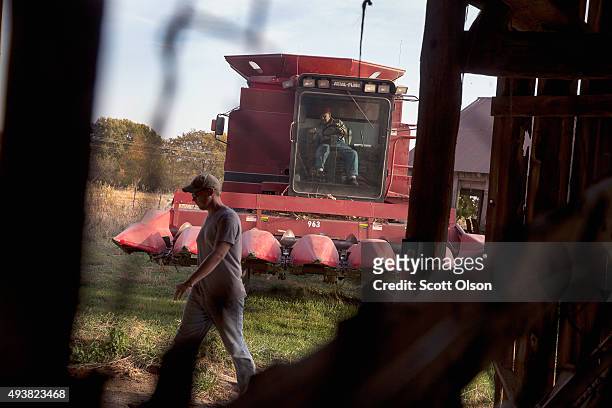 John Anderson guides his 93-year-old great uncle Lyman Howe into the barn after they finished combining corn on the family farm on October 22, 2015...