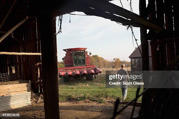 John Anderson guides his 93-year-old great uncle Lyman Howe into the barn after they finished combining corn on a family farm on October 22, 2015...