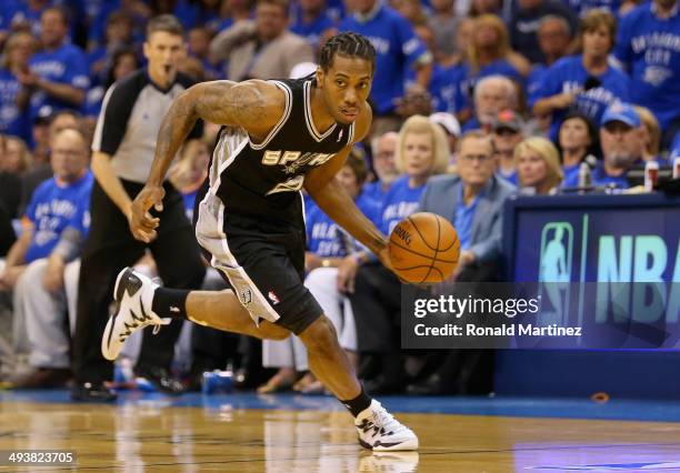Kawhi Leonard of the San Antonio Spurs dribbles after a turnover in the first quarter against the Oklahoma City Thunder during Game Three of the...