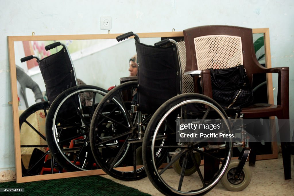 A handicapped Palestinian woman behind the wheelchairs as...
