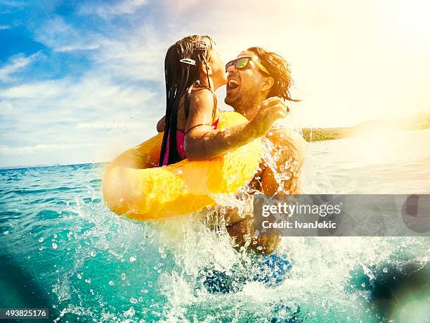 father and child jumping and having fun together in sea - beach family jumping stock pictures, royalty-free photos & images